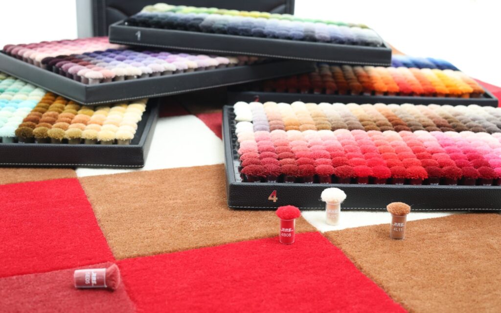 Zodiac rug colors inspired by astrology, featuring wool swatches from Aries red to Pisces lilac arranged in a celestial-themed layout.